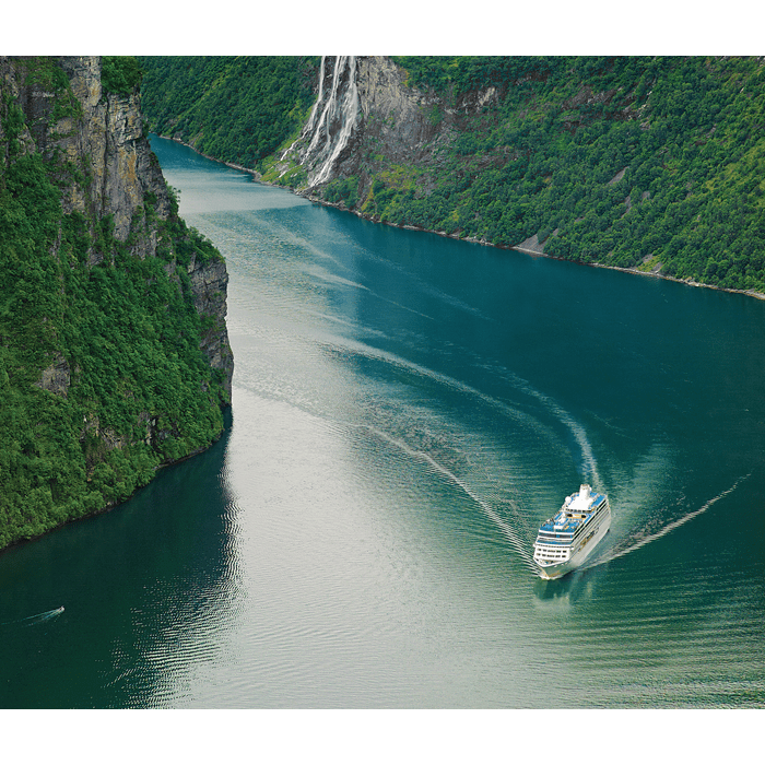 Oceania Cruises, a cuisine-focused cruise line, is pictured drifting along a green-colored coastline.