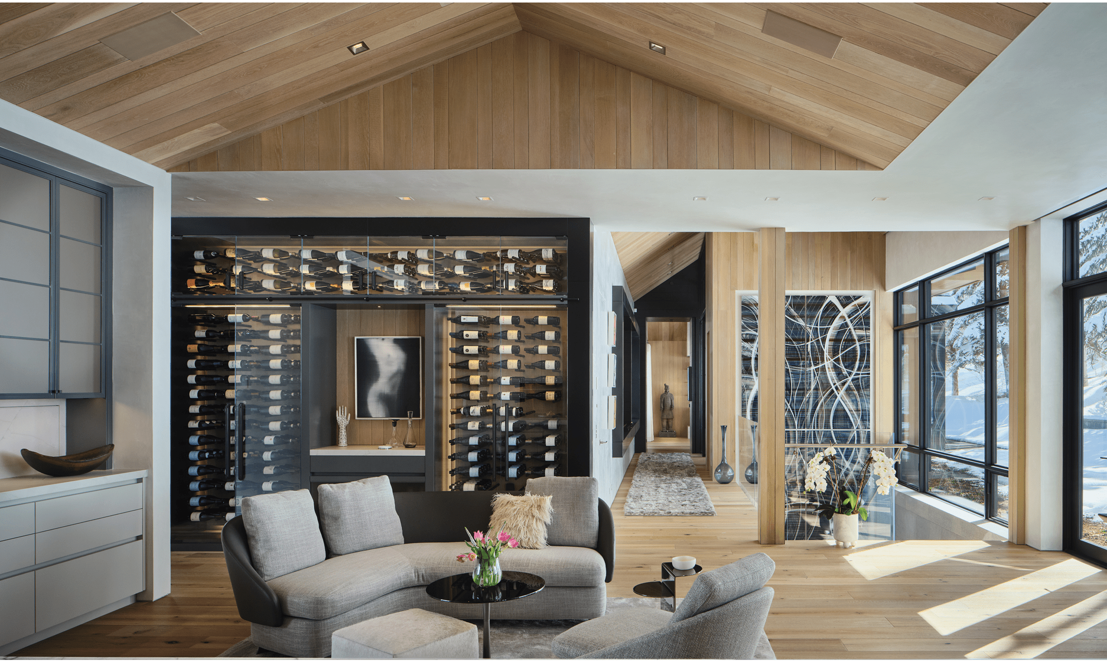 A lively wine area lines the back of the living area. The living area focuses on a neutral tone to complement the landscape.
