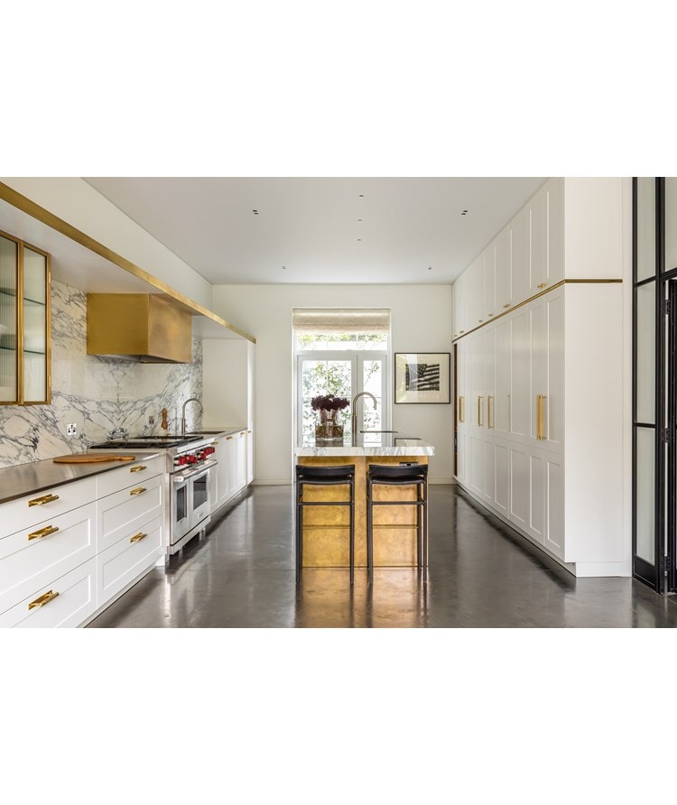 London based interior designer Samantha Todhunter uses utilitarian elements tucked away with brass and marble to create a kitchen with elegance.