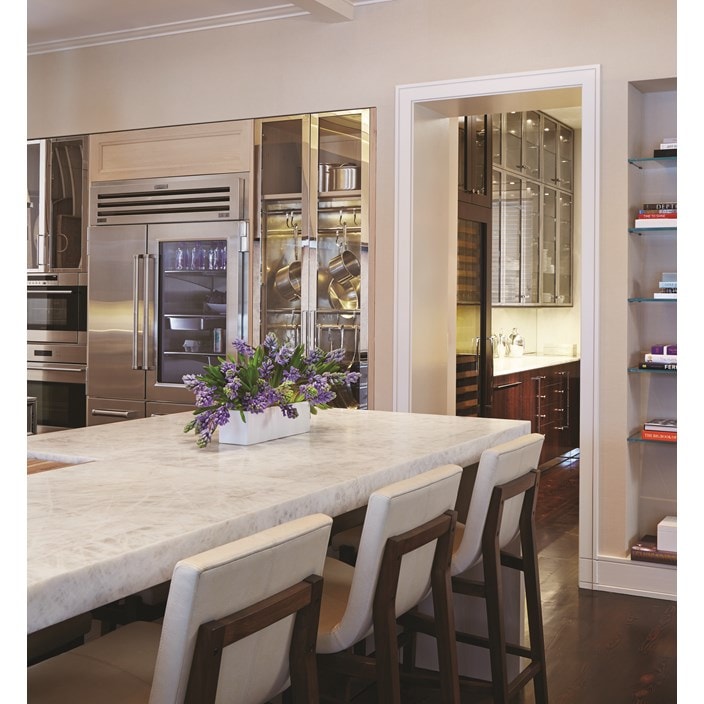 Luxury kitchen design offering warmth and comfort with wood paneling and wooden cabinetry featuring a seamless and hidden panel ready Sub Zero refrigerator.