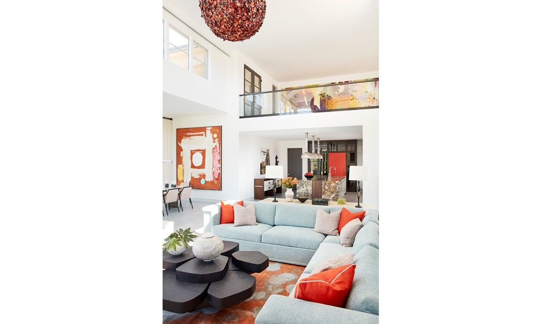 Cool tones of celadon mingle with bright accents of vibrant orange seen in textiles and artwork