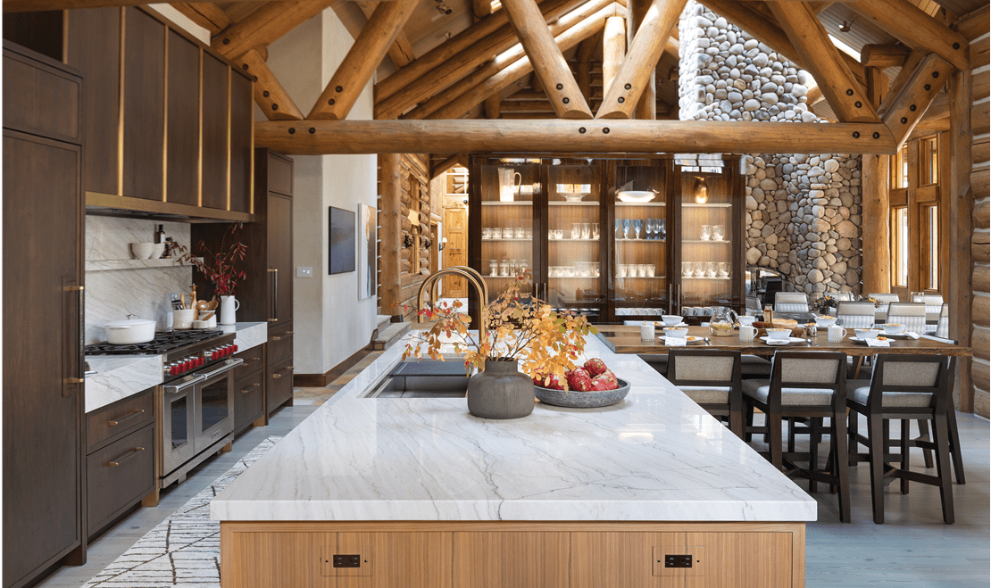 Transparent glass doors highlight an illuminated display and a light grey quartzite countertop outlines the kitchen island.