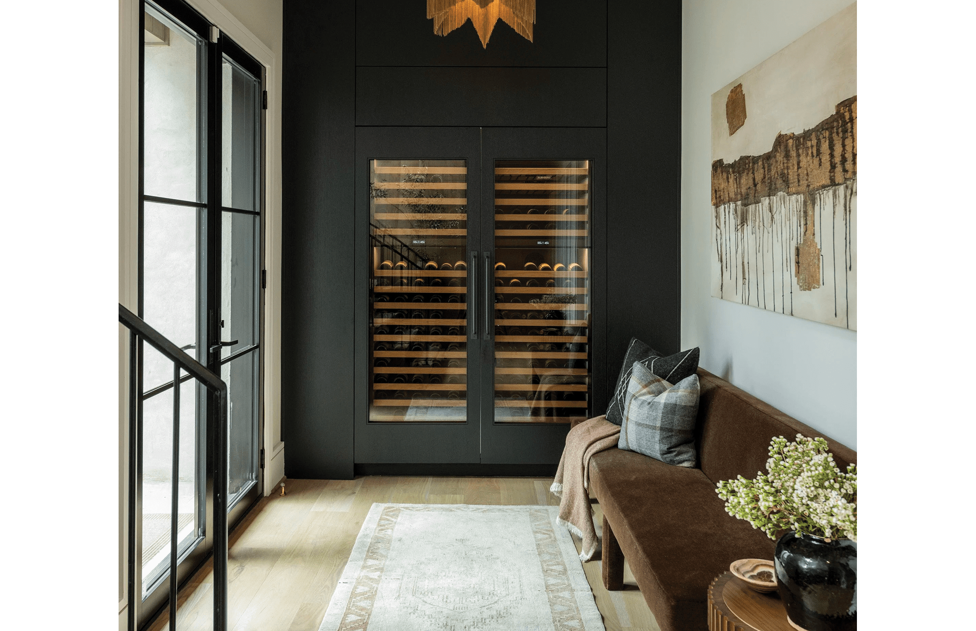 Two panel-ready Designer Series wine refrigerators in a cozy room with a door to the patio nearby.