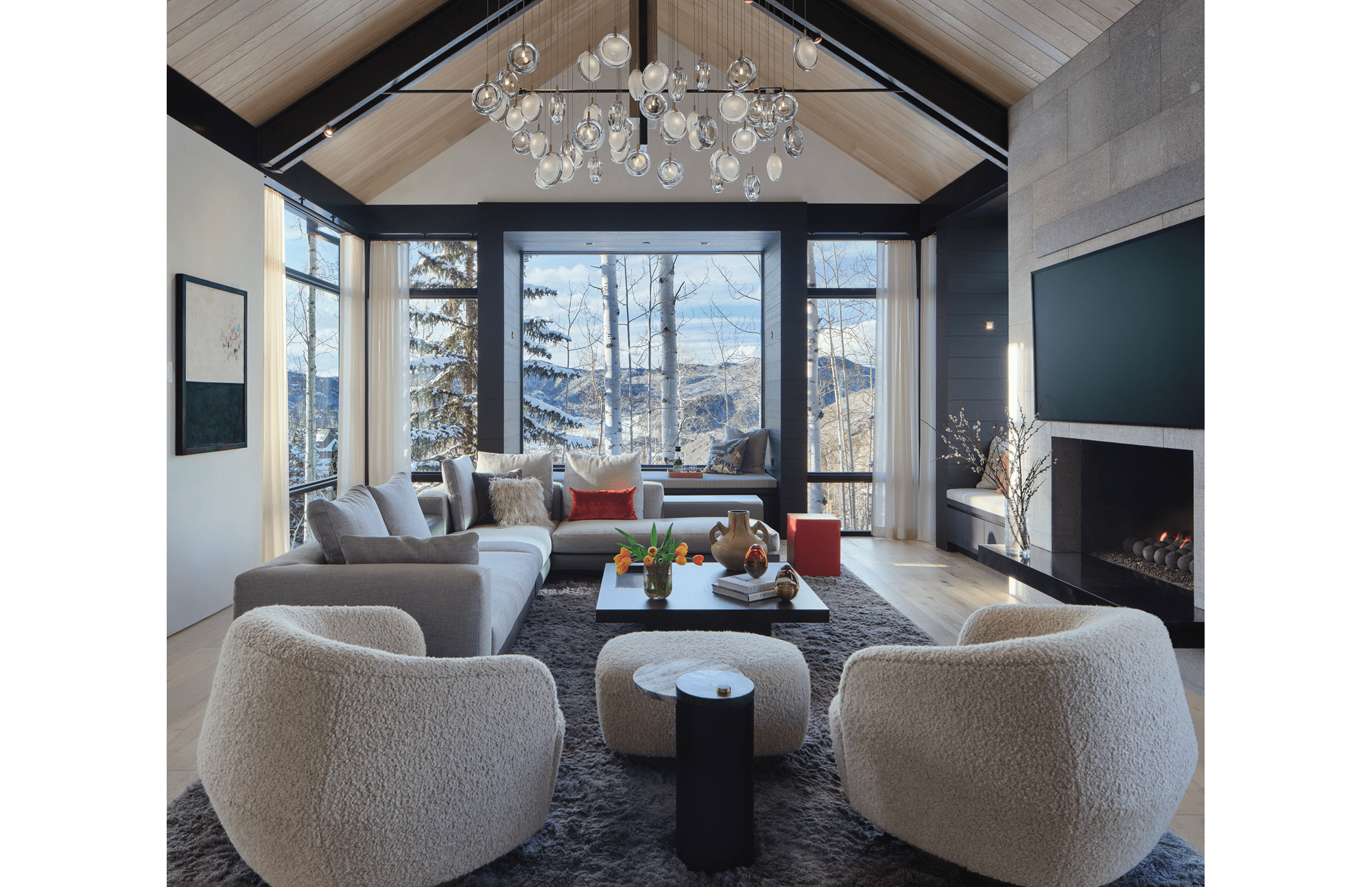 A cozy living room with fluffy love seats, a full coffee table, and a view into the Rockies for this Colorado home.