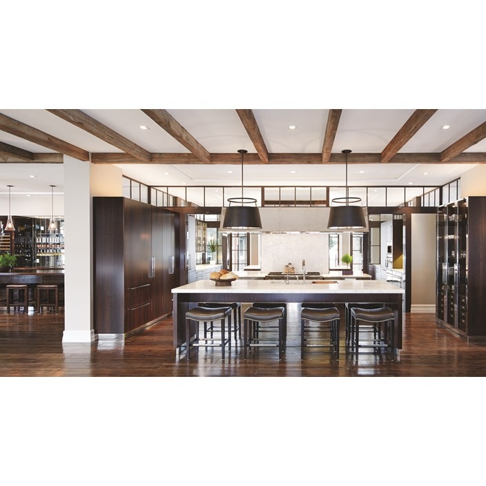 Luxury kitchen design offering warmth and comfort with wood paneling and wooden cabinetry featuring a seamless and hidden panel ready Sub Zero refrigerator.