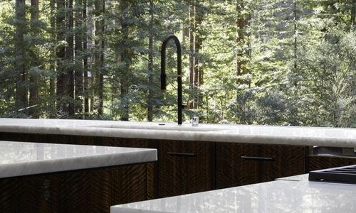 Sub-Zero Wine Storage blends perfectly with the dark hardwood brown floors, bright white walls, and stainless steel accents of this majestic Redwoods setting.