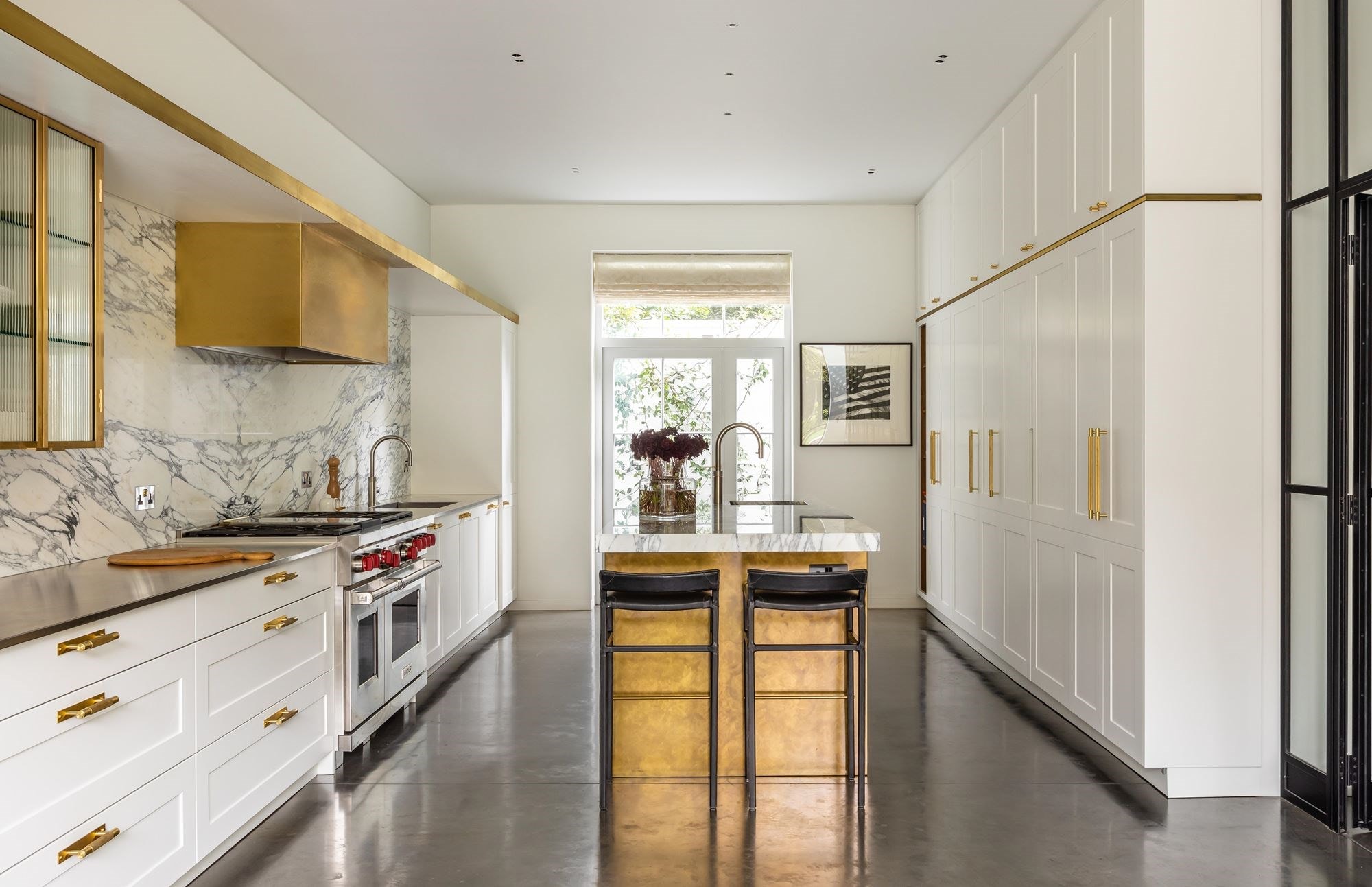 London based interior designer Samantha Todhunter uses utilitarian elements tucked away with brass and marble to create a kitchen with elegance.