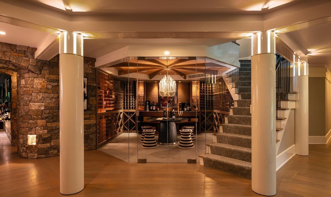 This sensational stone and glass-walled wine room reflects the overall architectural theme of the home.