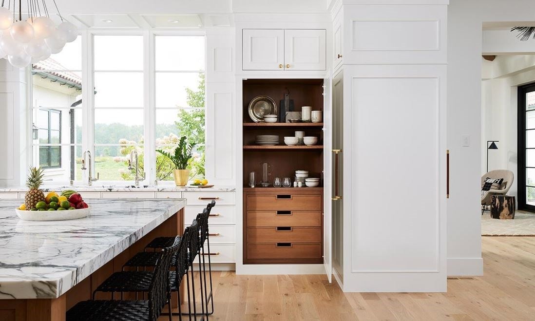 A jewel box of a pantry for storing dry goods is entirely clad in white oak paneling