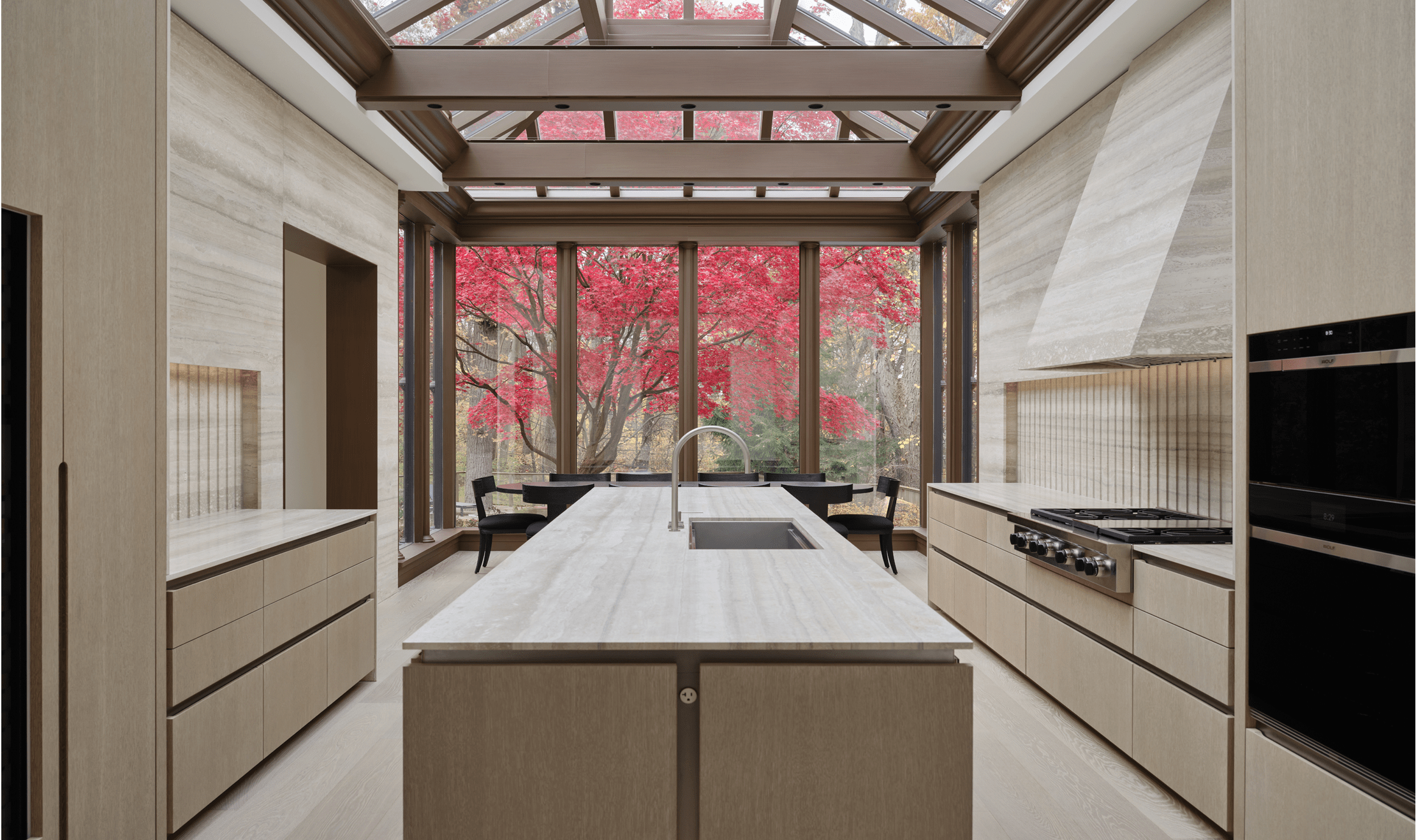 A full view of Trevor Wallace's kitchen design with large windows allowing beautiful landscapes and natural light in.