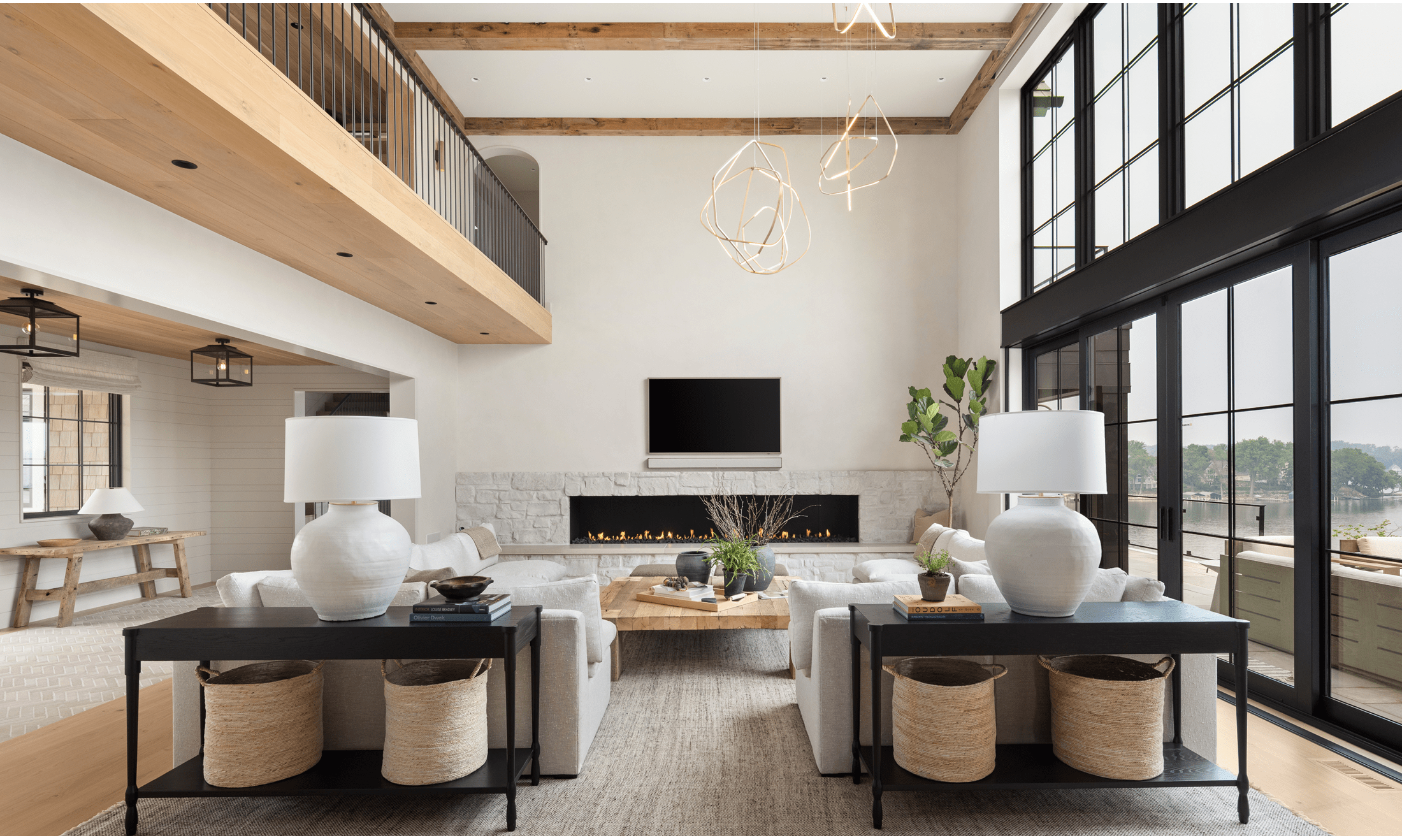 The main living room of the home features two L-shaped couches facing an installed fireplace below a mounted television.