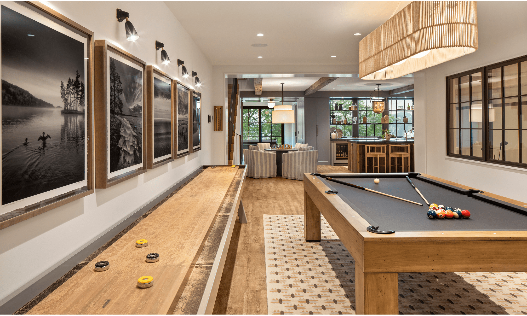 The downstairs bar area has a Sub-Zero Undercounter Beverage Center. The space includes a game room with a shuffleboard and pool tables.