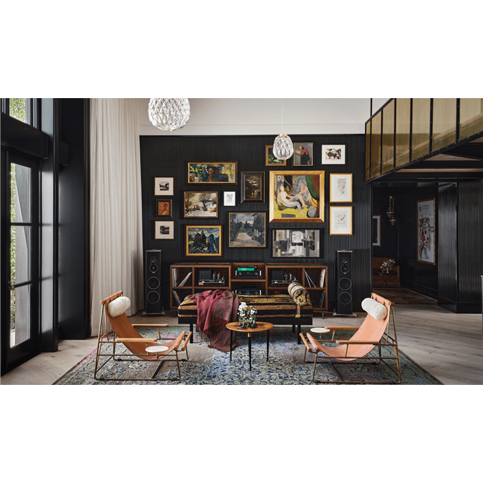 Fern Santini loves to show her creativity. This can be seen in this unique living space with photos, chairs, and speakers.