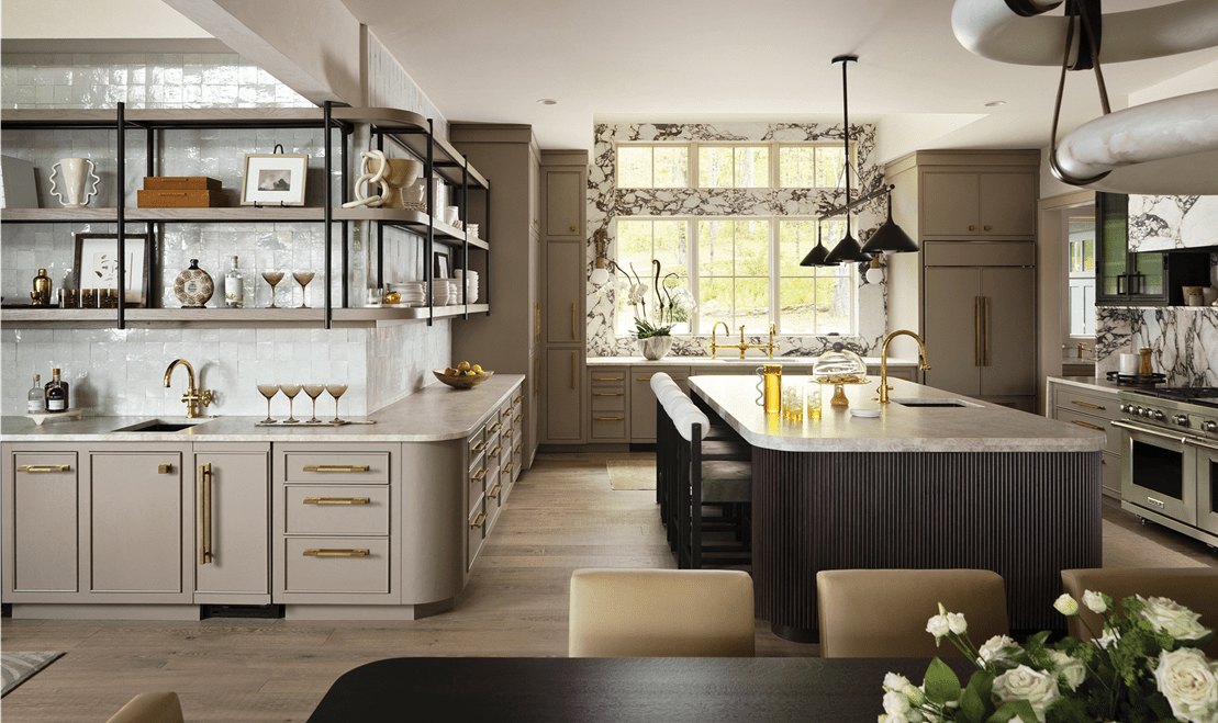 Modern kitchen with beige cabinets, marble island countertop built-in Wolf range, and large windows with natural light.