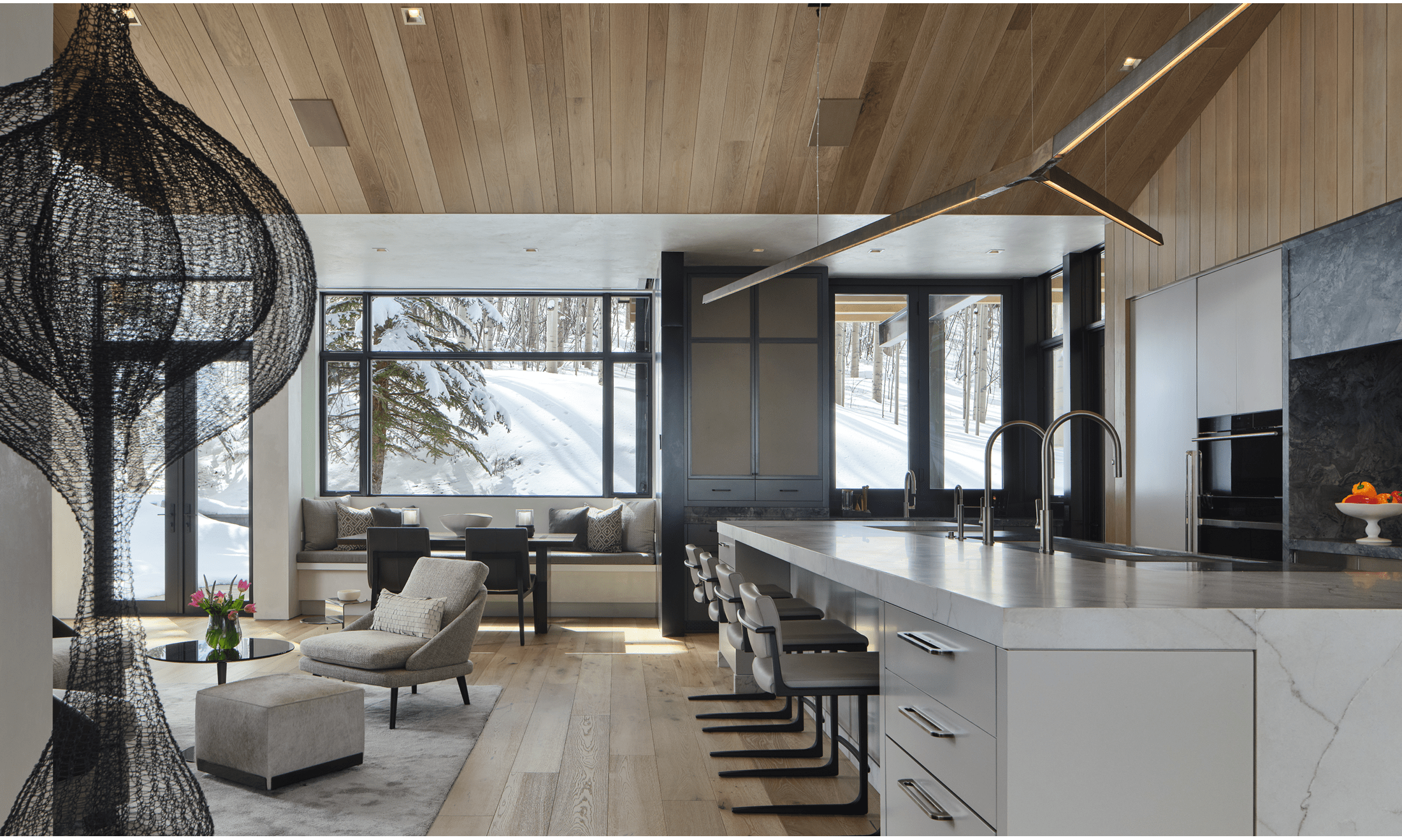 A wooden and marbled kitchen area is the prominent space within this beautiful Aspen area home.