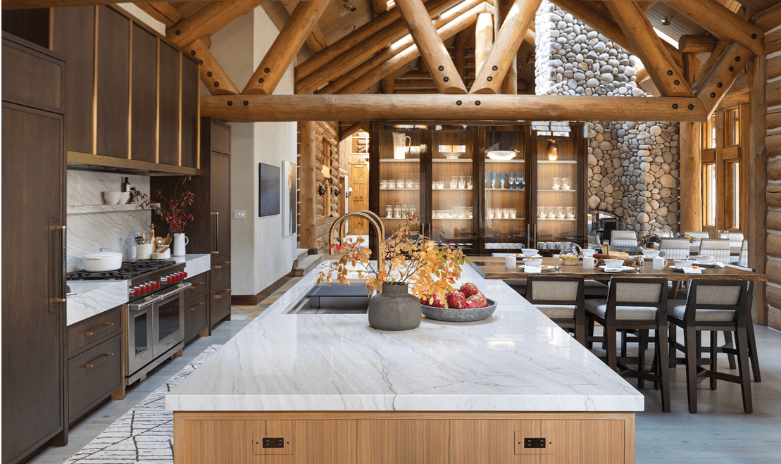 Transparent glass doors highlight an illuminated display and a light grey quartzite countertop outlines the kitchen island.