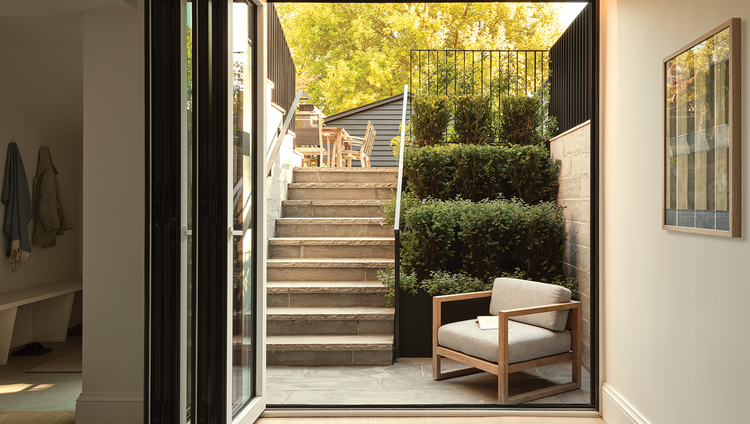 A full-extending sliding door connects the living area with the outside patio of this luxury, modern home.