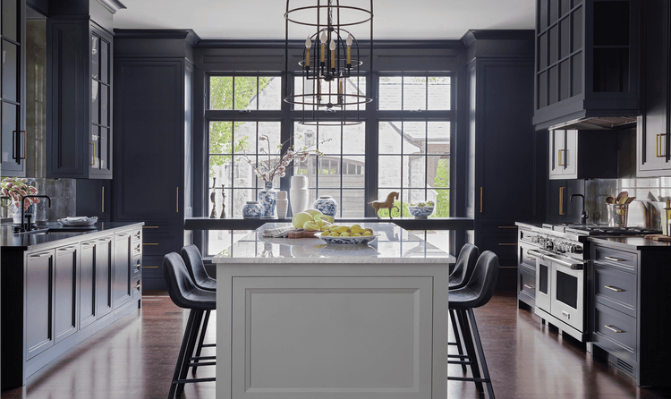 A wide shot of Karen Ferguson's design that emphasizes the open lighting and deep navy-hued colors of the kitchen.