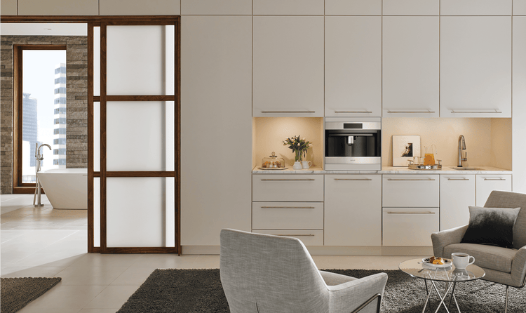 The Wolf Built-In 24-inch Coffee System fits seamlessly in this minimalist home featuring a Wolf 30-inch Warming Drawer.