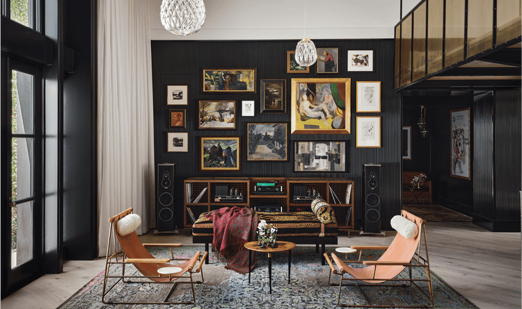 Fern Santini loves to show her creativity. This can be seen in this unique living space with photos, chairs, and speakers.