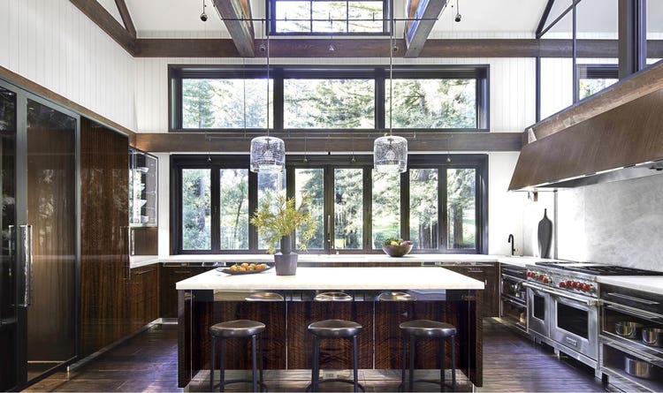 Sub-Zero Wine Storage blends perfectly with the dark hardwood brown floors, bright white walls, and stainless steel accents of this majestic Redwoods setting.