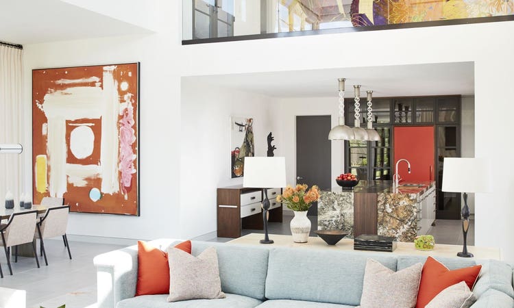 Cool tones of celadon mingle with bright accents of vibrant orange seen in textiles and artwork