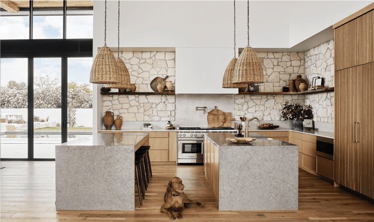 The kitchen features Woven Tulum pendant lights from Modern Nest hang above dual kitchen islands.