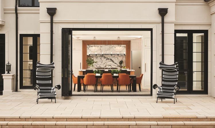 Entire dining room wall opens to stone patio and pool deck