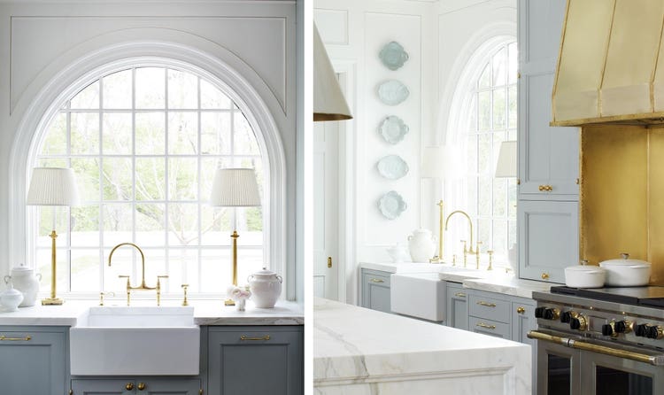 Twin table lamps frame the radius window and farmhouse sink.