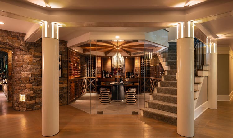 This sensational stone and glass-walled wine room reflects the overall architectural theme of the home.