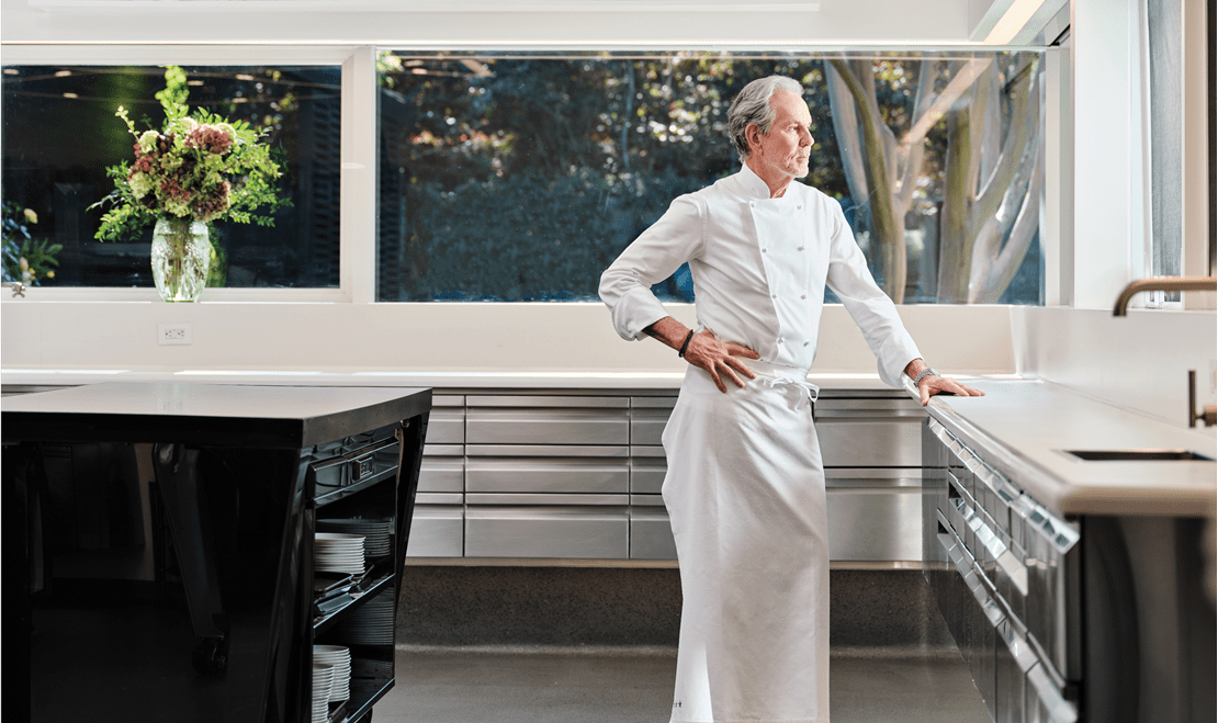 The kitchen of The French Laundry, designed to let in light from multiple windows, as Chef Keller poses contemplatively.