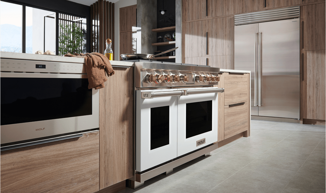This Wolf Dual Fuel Range with chrome knobs and white powder-ciated steel doors is the centerpiece of this kitchen.