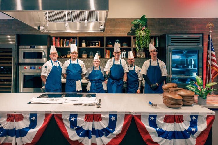 Executive Chef Josef Zimmermann of the Luminary Hotel, pictured third from the right, stands alongside his culinary team during the event.