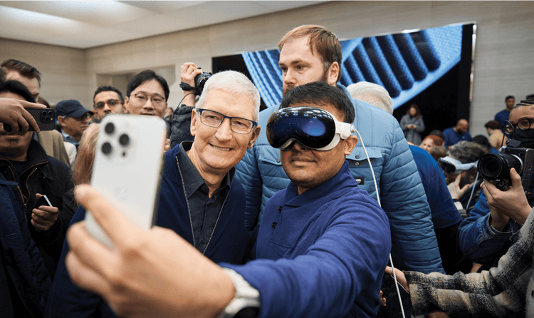 A customer wearing an Apple Vision Pro poses with Apple's CEO Tim Cook for a selfie.