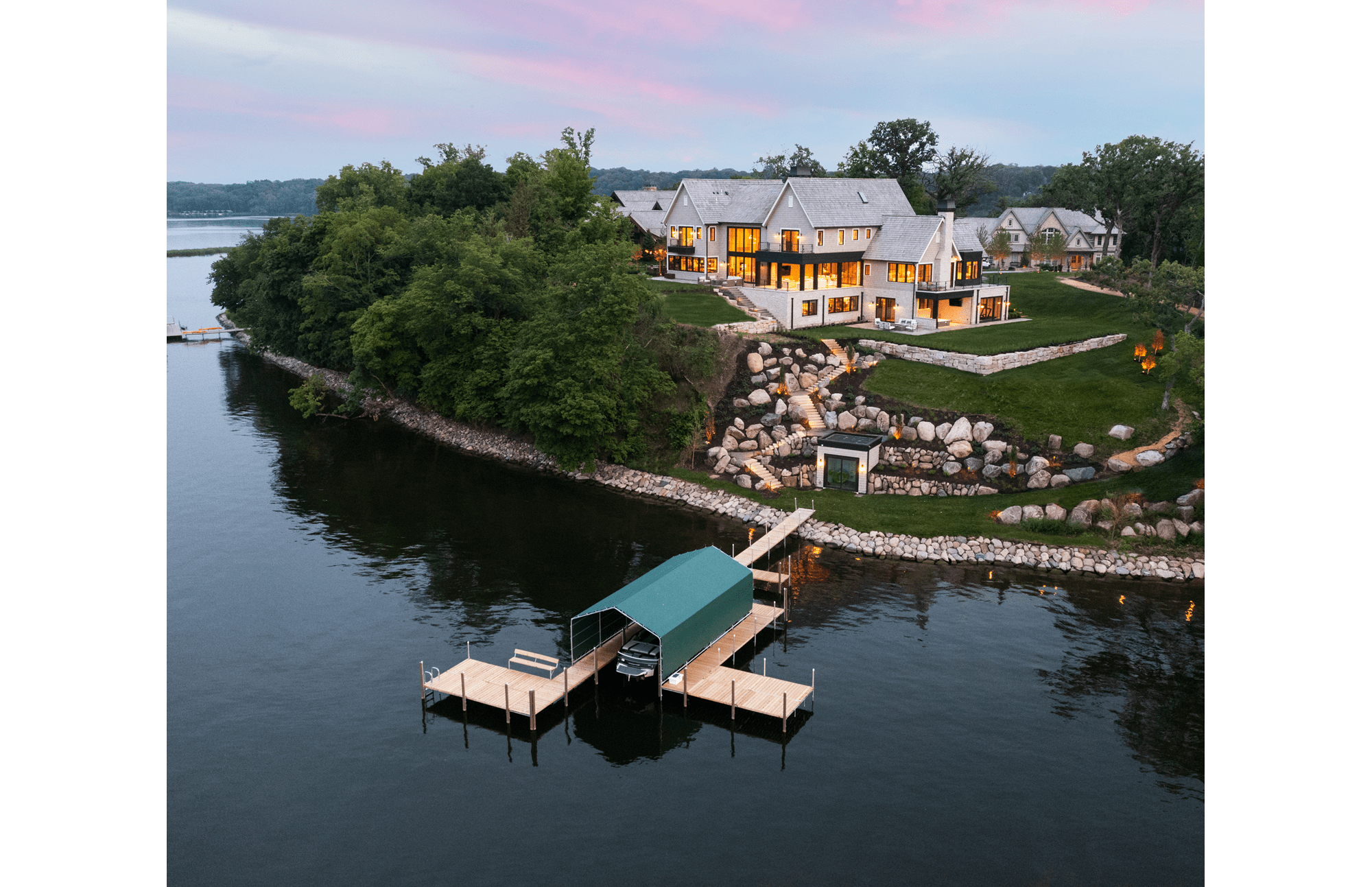 A modern, luxury residential home on the banks of Lake Minnetonka with a large dock for boating activities.