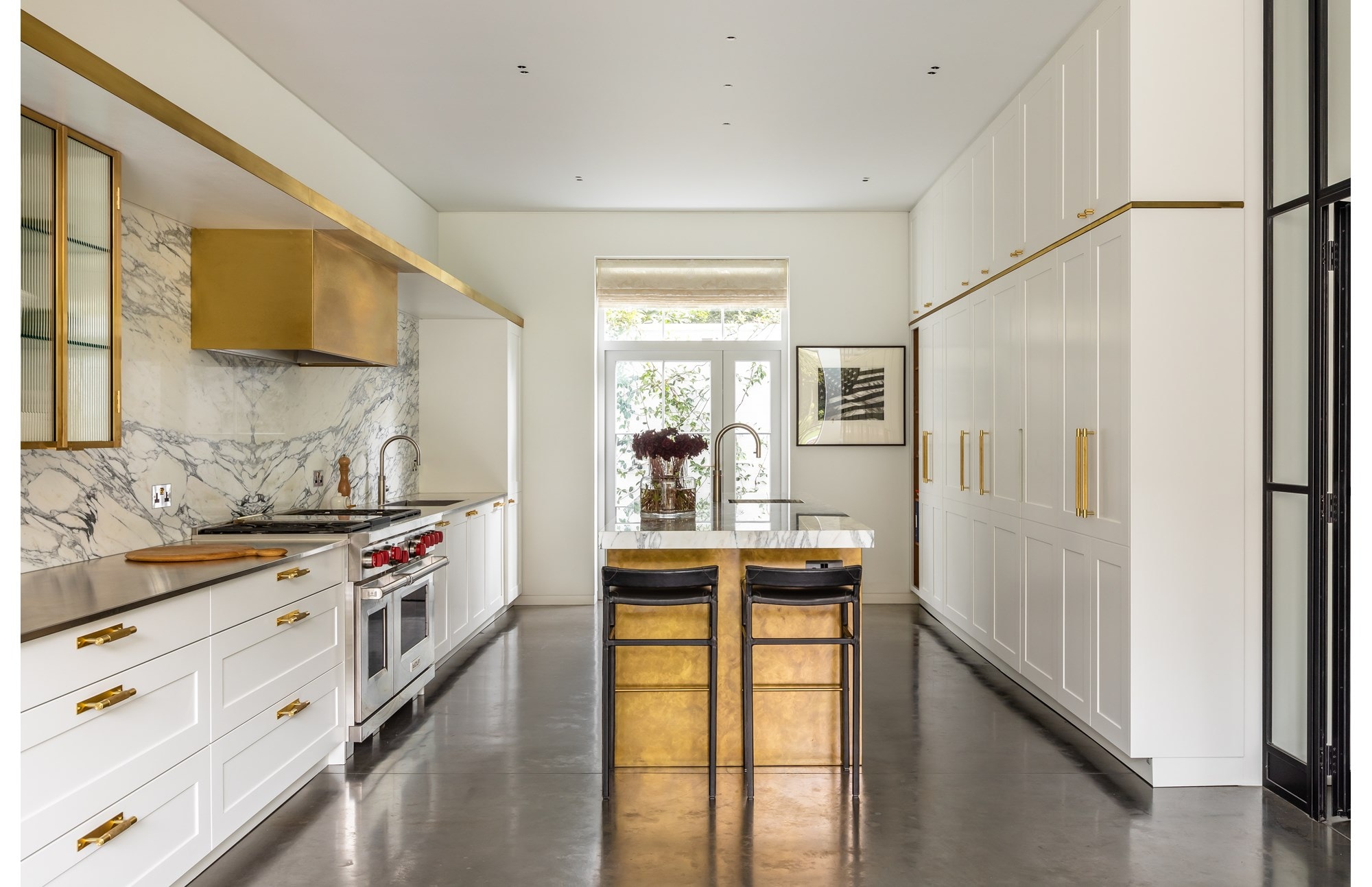 London based interior designer Samantha Todhunter uses utilitarian elements tucked away with brass and marble to create a kitchen with elegance.