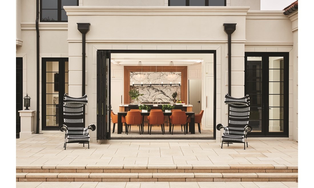 Entire dining room wall opens to stone patio and pool deck