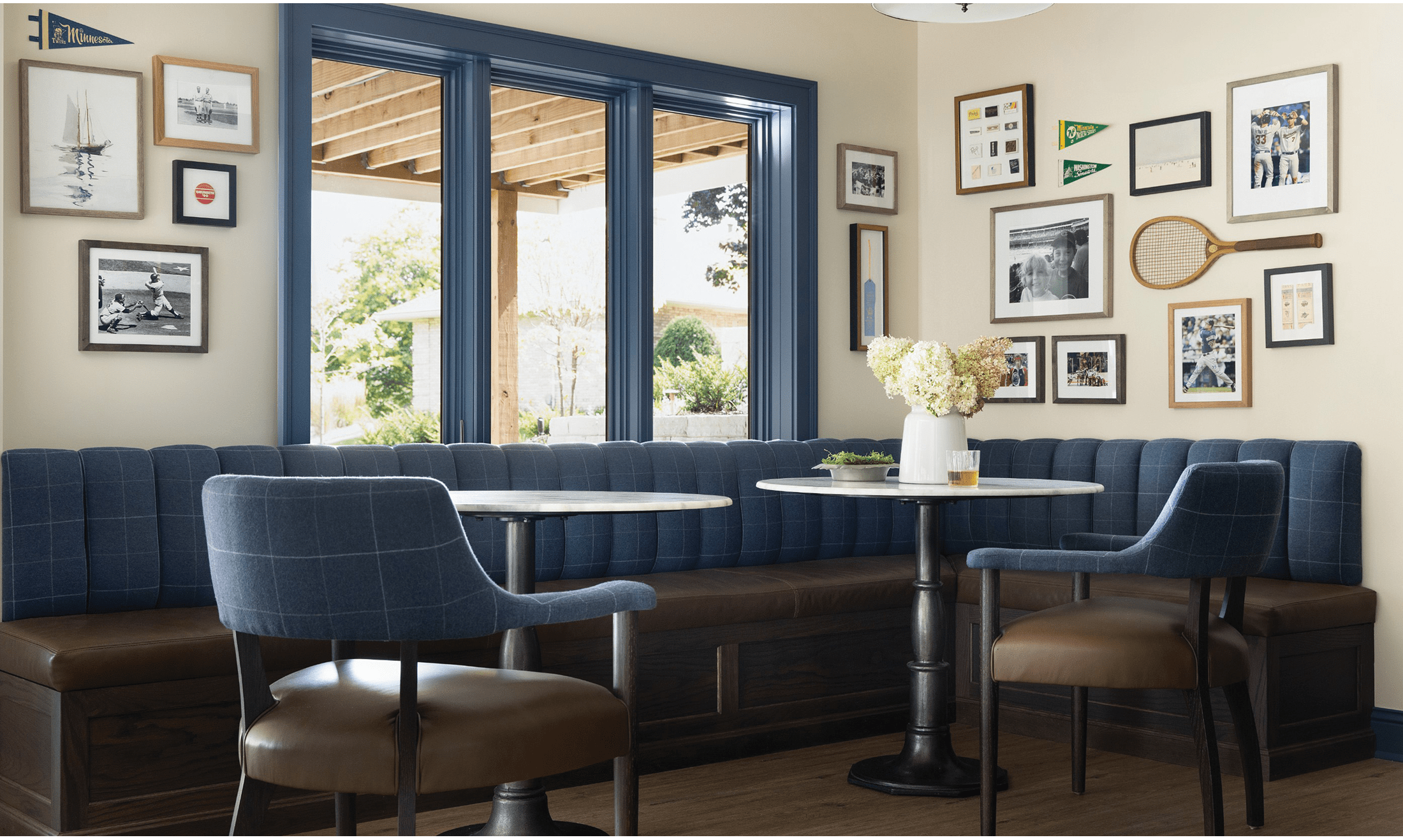 A blue and brown themed kitchen featuring multiple pictures hung on the wall.