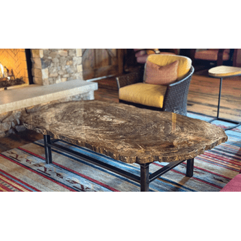 Within the barn sits a cozy fireplace featuring a beautiful wooden table resembling the reclaimed wood interior.