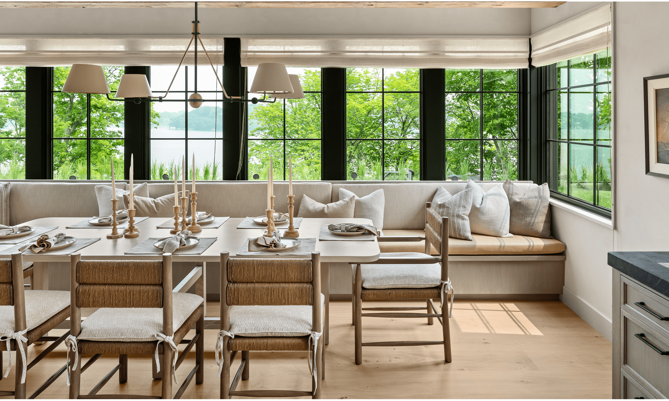 The built-in banquette table has extra chairs on one side and a long wall couch on the other.