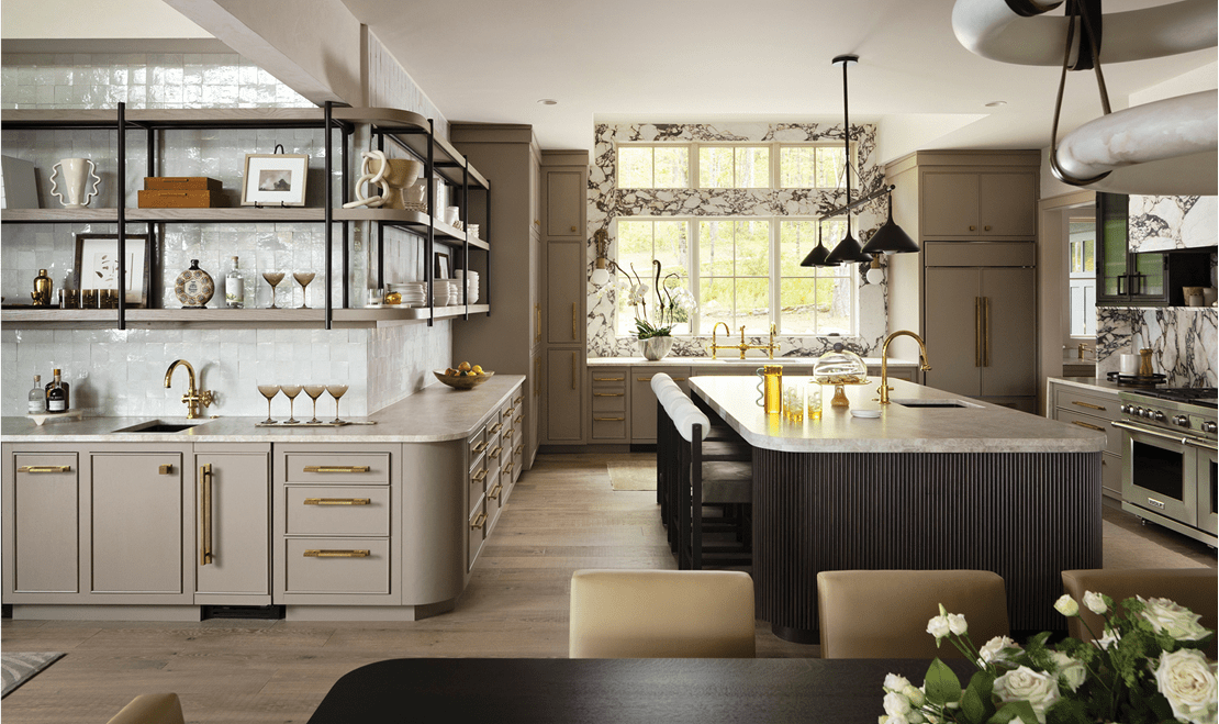 Modern kitchen with beige cabinets, marble island countertop built-in Wolf range, and large windows with natural light.