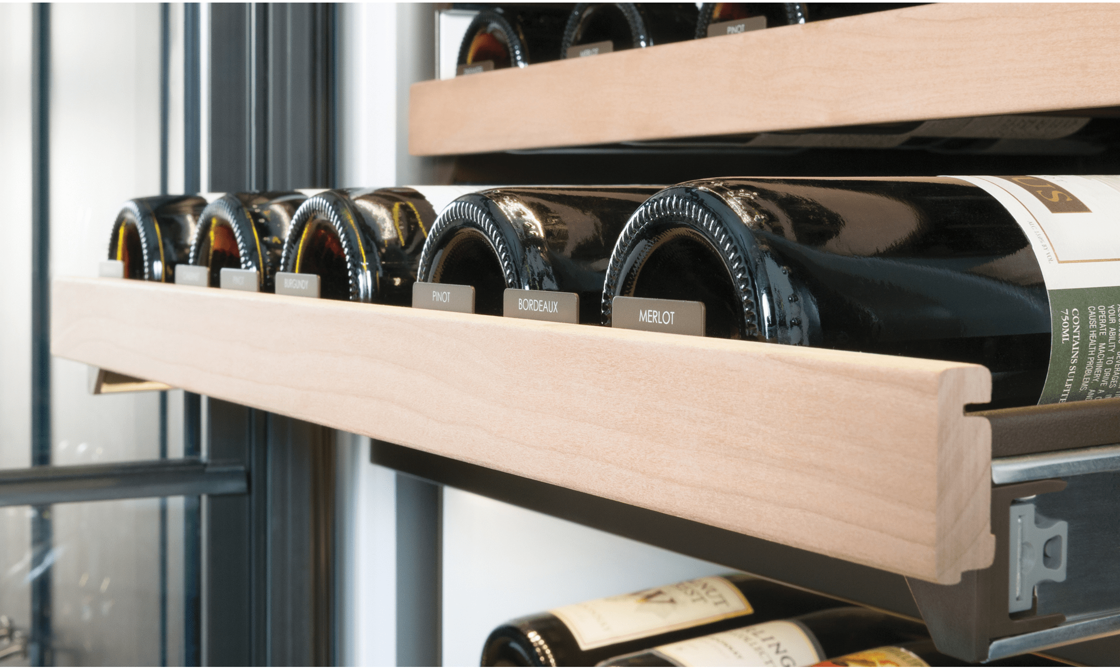 A closeup of a wine bottle rack in a luxury wine storage refrigerator.