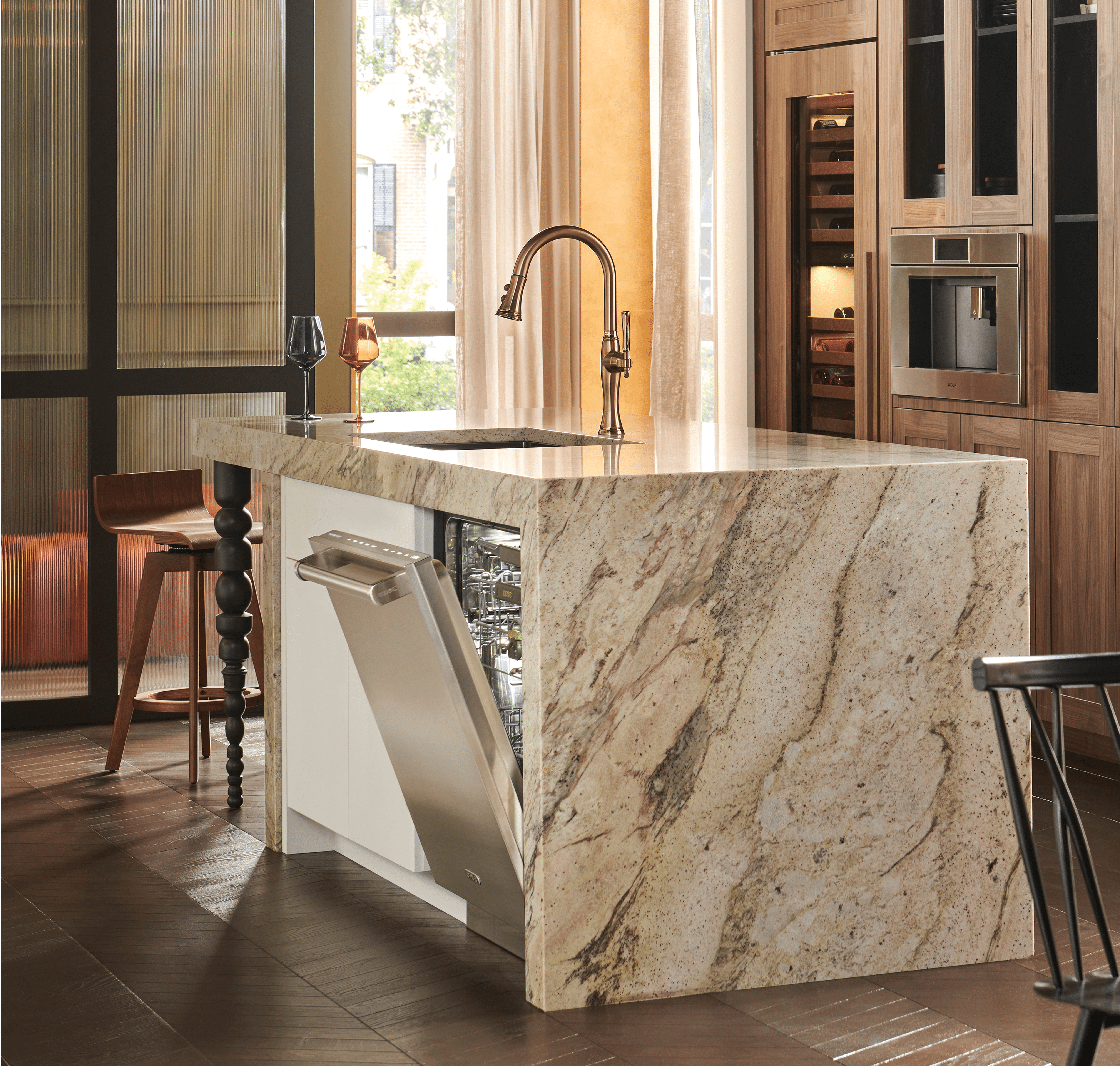 A built-in, Cove stainless-steel dishwasher opened slightly, allowing the empty interior to be shown.