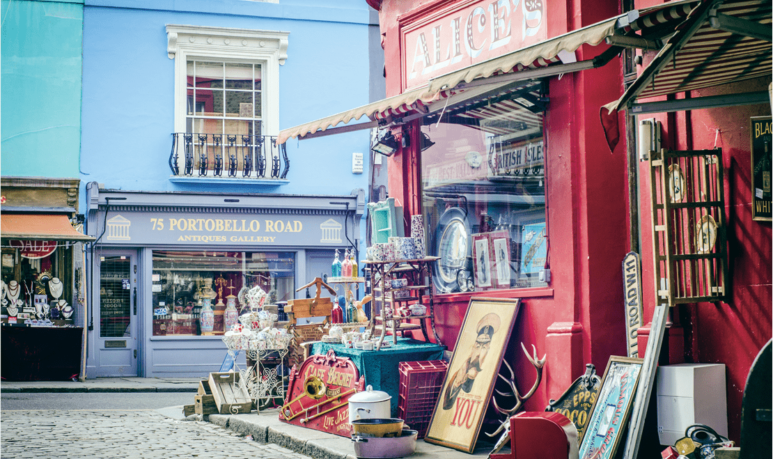 Portobello Road in London near Alice's antique shop with numerous vintage items neatly placed outside the store.