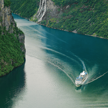 Oceania Cruises, a cuisine-focused cruise line, is pictured drifting along a green-colored coastline.
